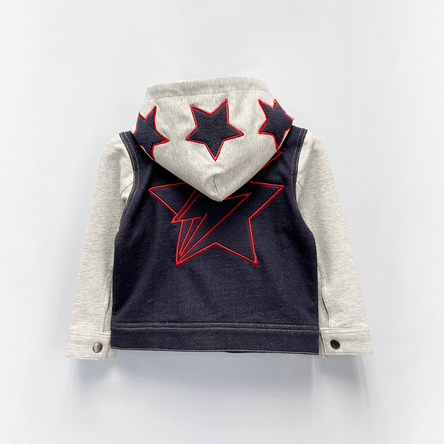 
                  
                    Back View – Boys’ Knit Denim Hoodie Jacket with Red-Outlined Star Graphics and Gray Sleeves
                  
                